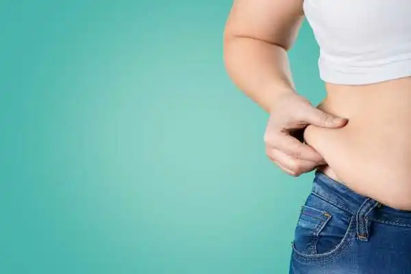 Image of woman pinching her love handles to show weight gain Wincanton